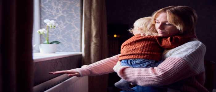 Woman checks radiator for warmth.