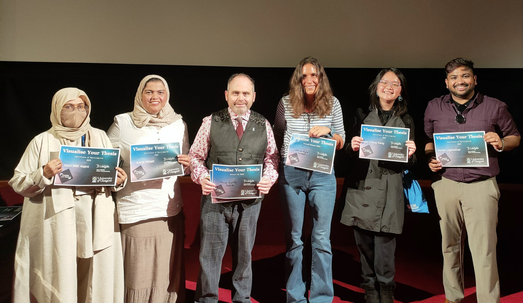 Six students standing on a stage holding certificates