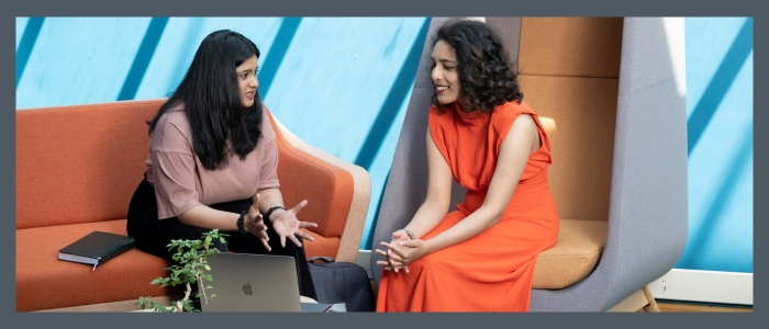 For decorative puposes only - two female students sitting on separate seats talking to each other