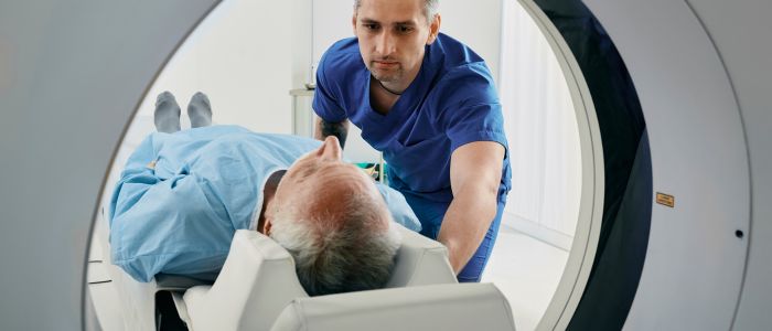 Doctor helping a patient into a CT Scanner