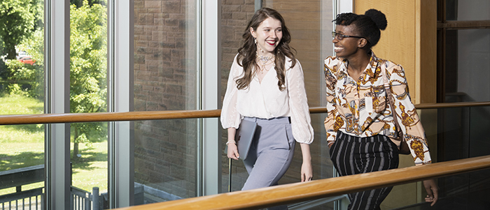 Students walking through a hallway in front of a window at the University of Glasgow Dumfries campus