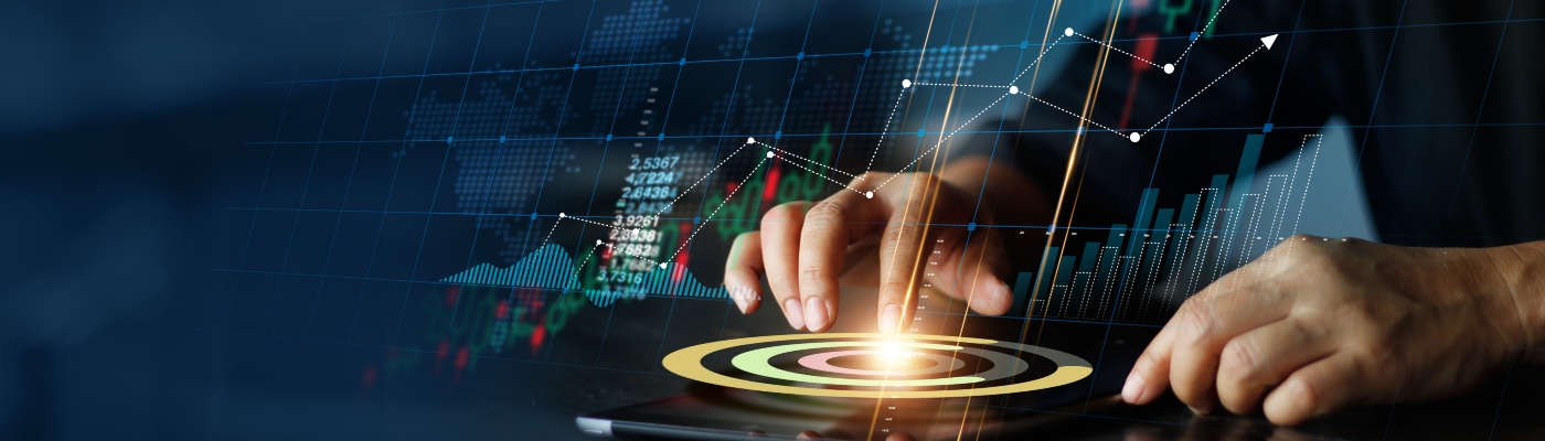 Hands working on a tablet with economic graphics in the background