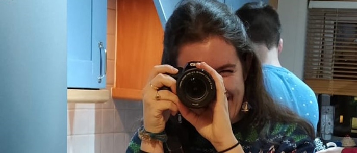 Female pointing a camera at the camera 