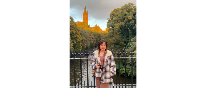 Student standing on bridge in front of GU 