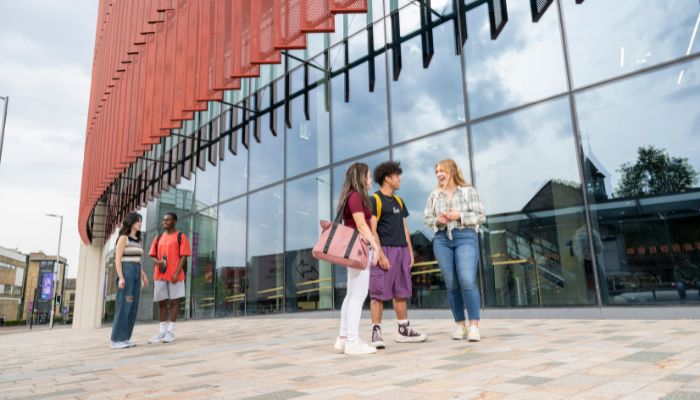 Group of students chatting outside the James McCune Smith building