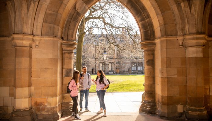Students standing under the arch at the main building quadrangle