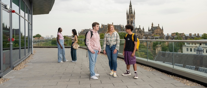 Students on JMS viewing deck with view of University tower in background