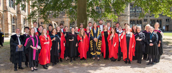 the UofG Chapel Choir group under a tree in the quadrangle