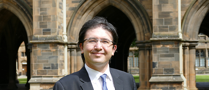 Dr Yusuf Soner Baskaya standing in the Cloisters at the University of Glasgow for a profile photo