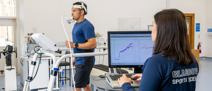 A sport science student monitoring a participant's performance using specialist equipment