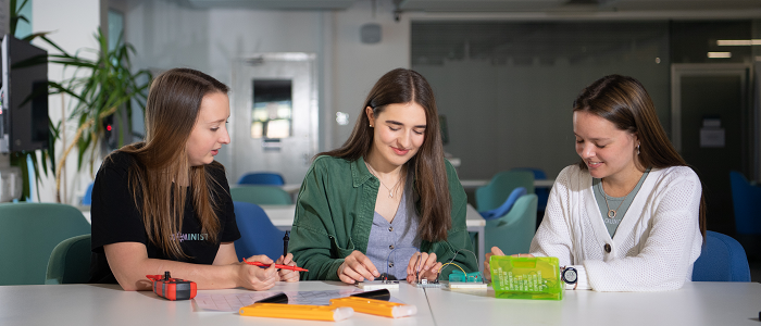 Three engineering students sitting at a table together