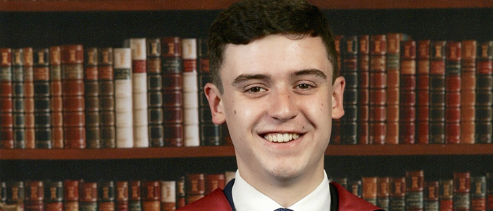 Aaron Clark Portrait Graduation Photo with bookcase backdrop