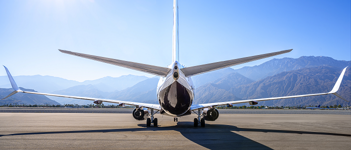 Modern aircraft on landing stip with mountains in background