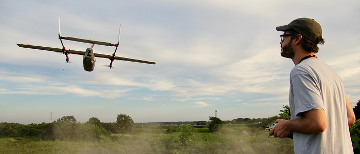 Man flying drone outdoors in rural setting