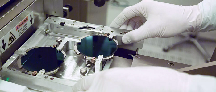 Gloved hands touching equipment in nanofabrication hub