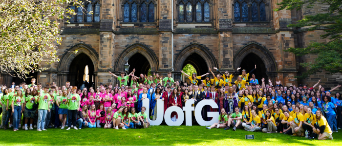 Lots of student helpers at Welcome Week/Freshers Week 2024 crowded around UofG pop up letters celebrating