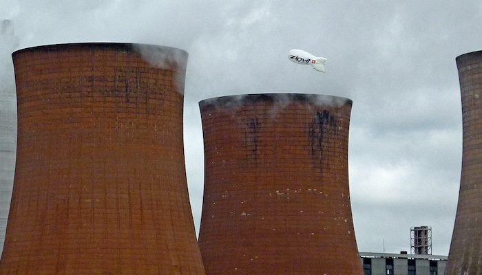 Three tall, curved brick towers with steam coming out of the top, at Rugeley power station