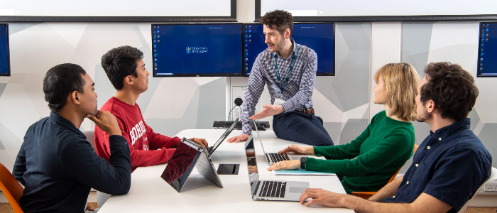 A group of staff sat together at a table in discussion