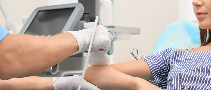 Medical professional performs ultrasound on patient elbow