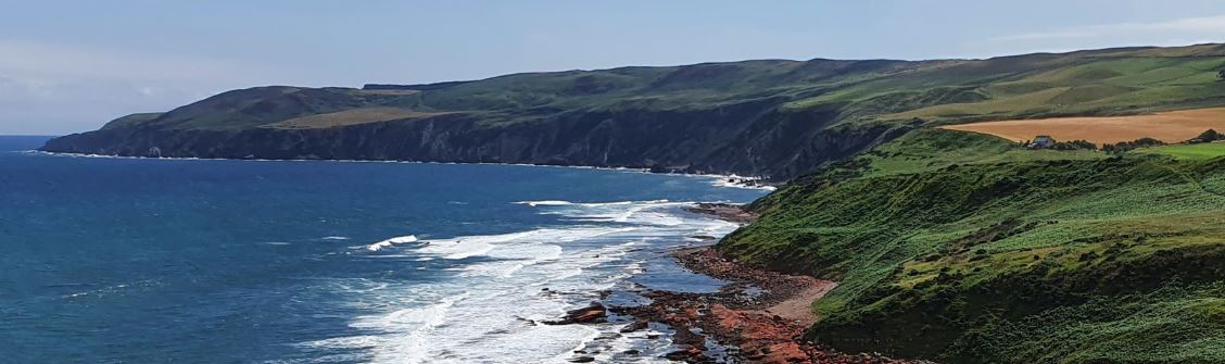 A rocky shoreline of Scotland, with a flattened top and a steeply inclined edge