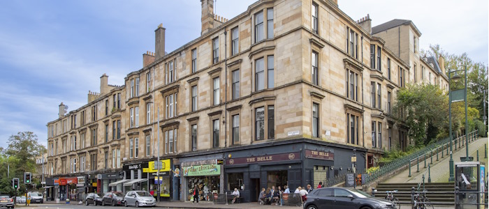 Image of a corner block of flats with restaurant underneath on Great Western Road. Image for illustrative purposes to show an example of residential property in Glasgow.