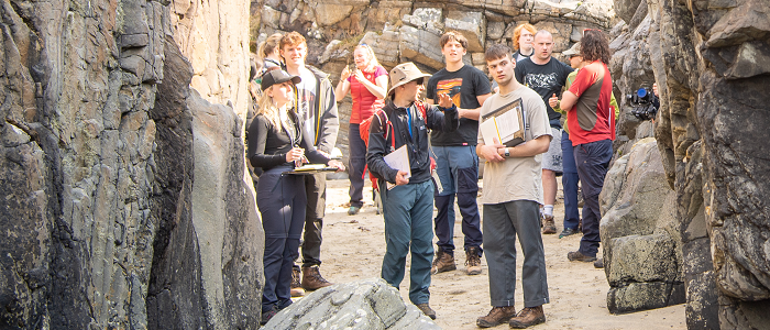 Students on a fieldtrip surrounded by rocks