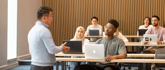 Lecturer presenting to students with laptops