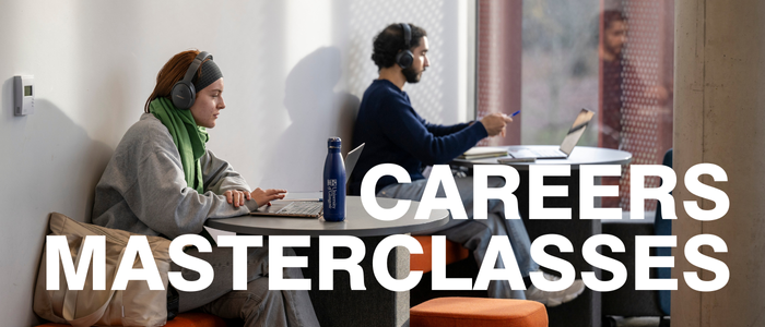 Two students sitting at tables on their laptops in the James McCune Smith Learning Hub