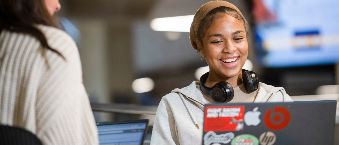Student smiling looking at their laptop