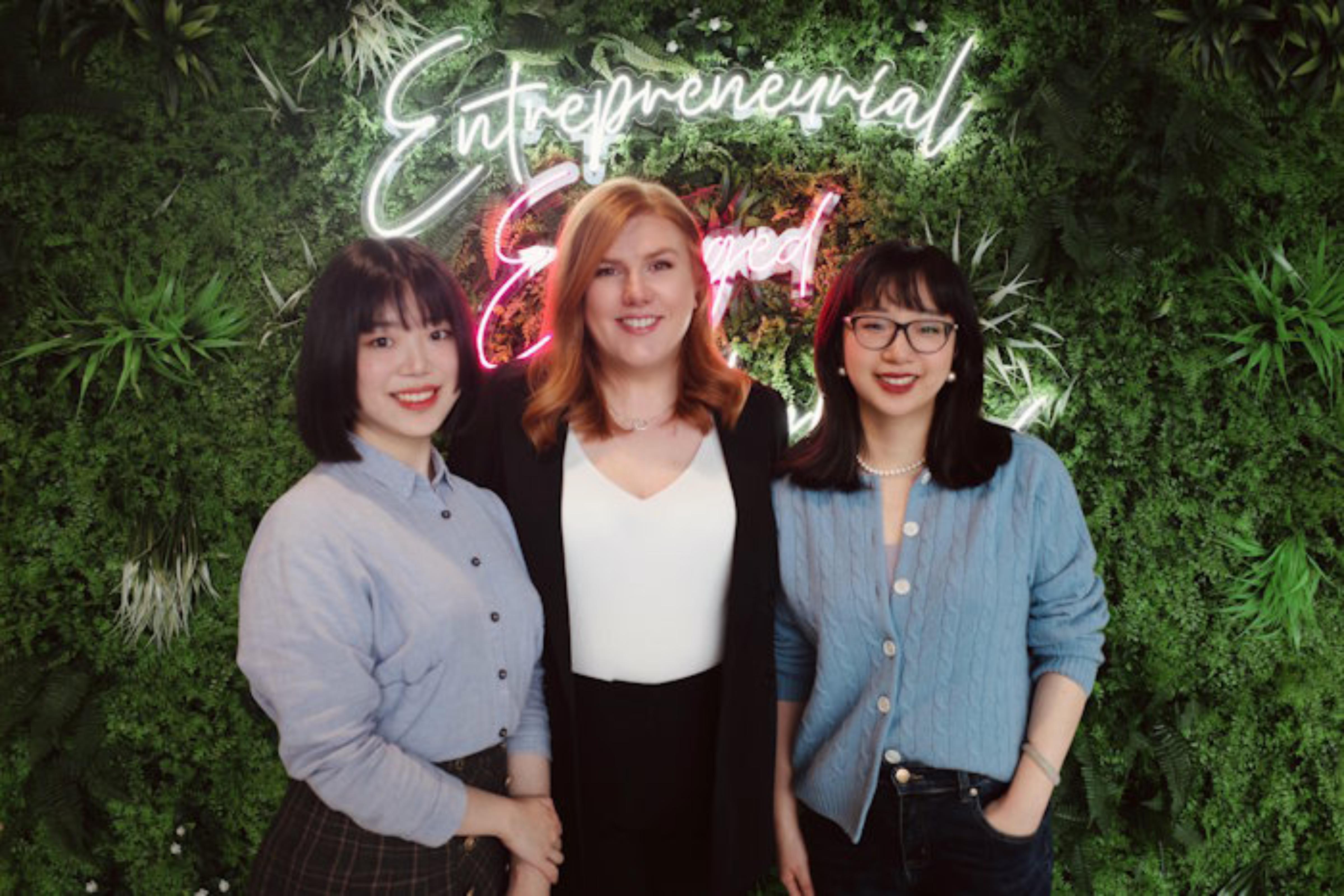 Three female members of the Alumni team pose in the ASBS building foyer.