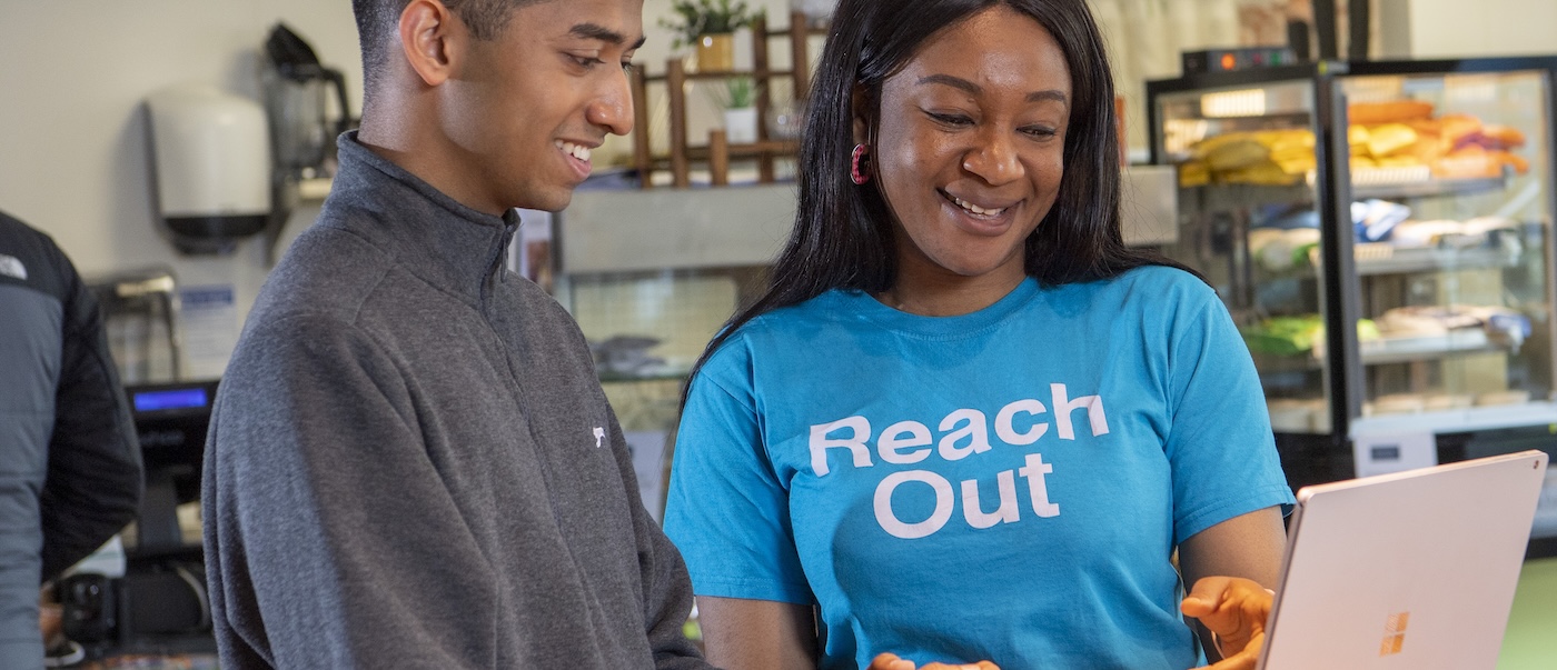 a reach out staff member helping a student