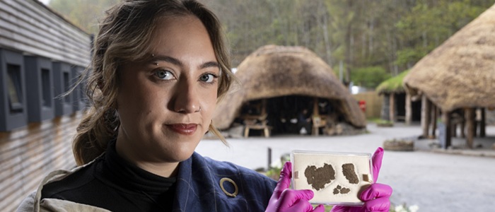 Experimental archaeologist Isobelle Hanby with the piece of woven fabric. Photo Martin Shields