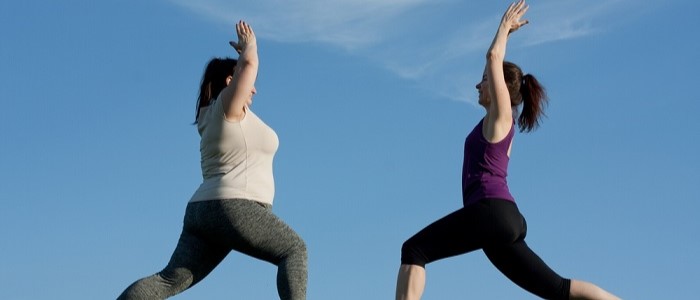 Two women exercising outdoors, doing yoga