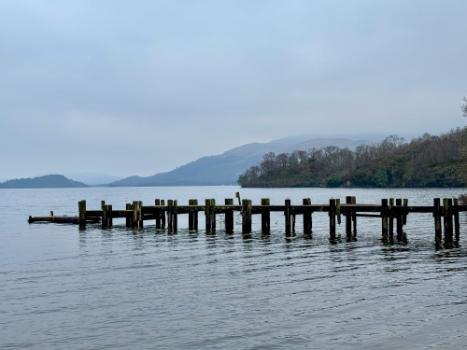Loch Lomond scenic landscape grey water and skies with aged wooden jetty