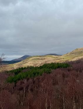 Hills in Loch Lomond grey cloudy background with some sun seeping through