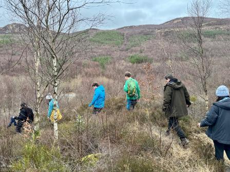 Six writing retreat participants walking through the bracken in Loch Lomond