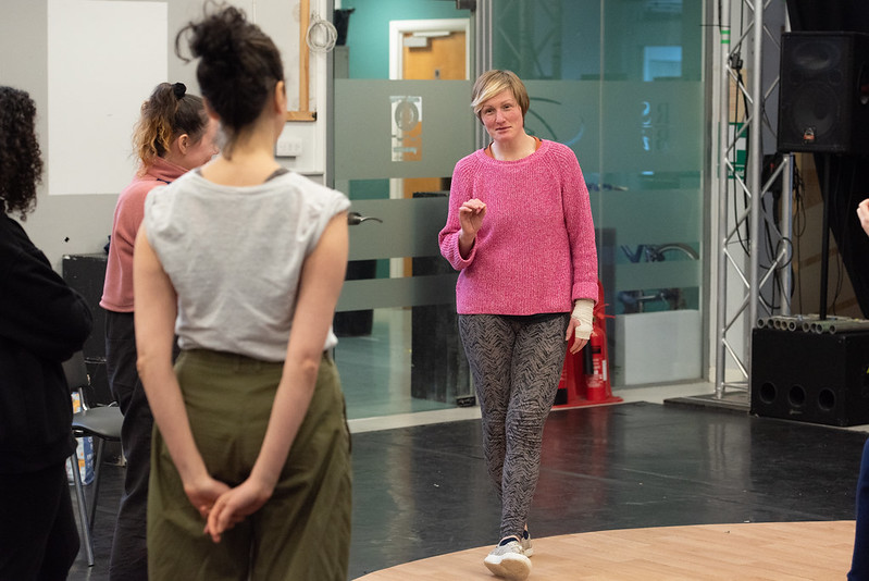 a teacher standing in front of students speaking