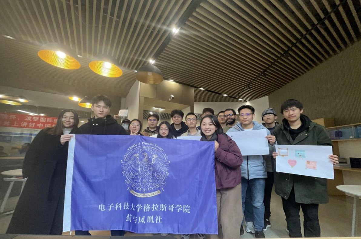 Students from the Thistle & Phoenix Society with their society's banner