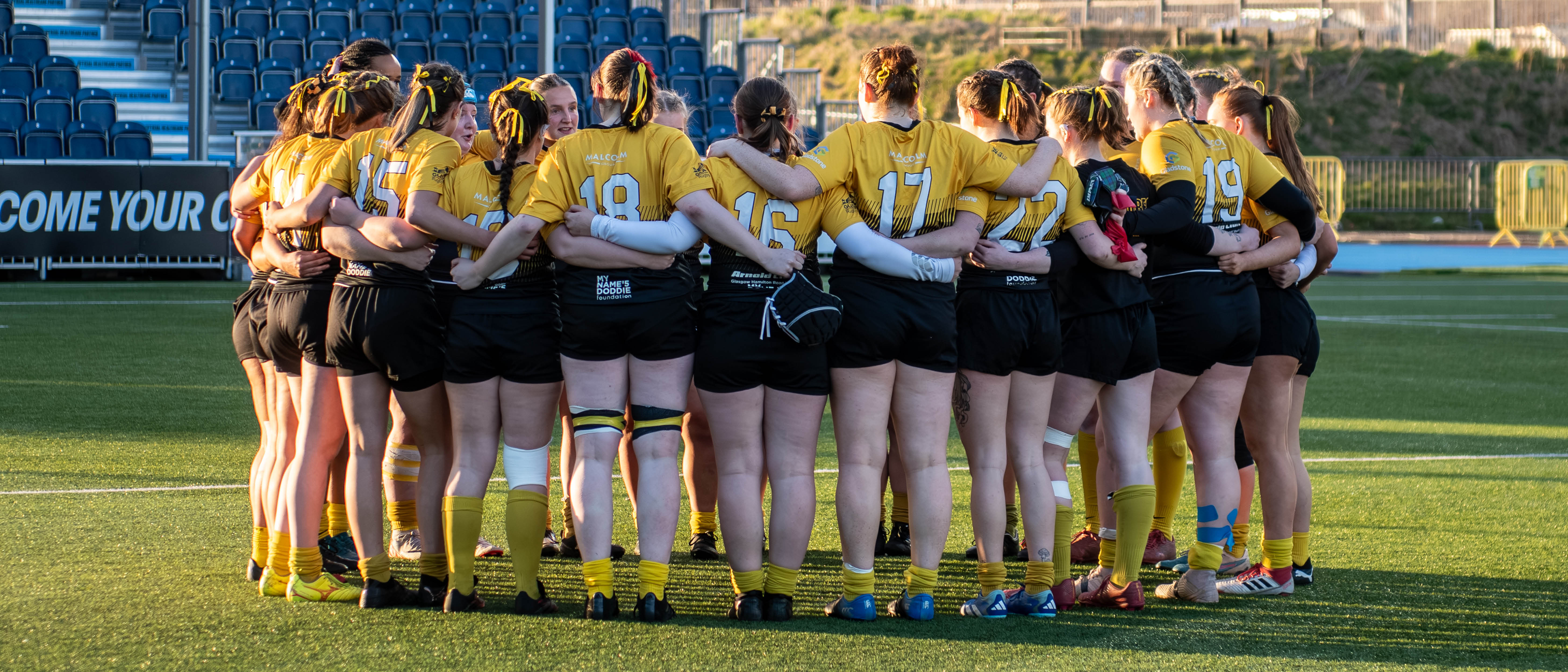 Glasgow Womens Rugby team in a huddle