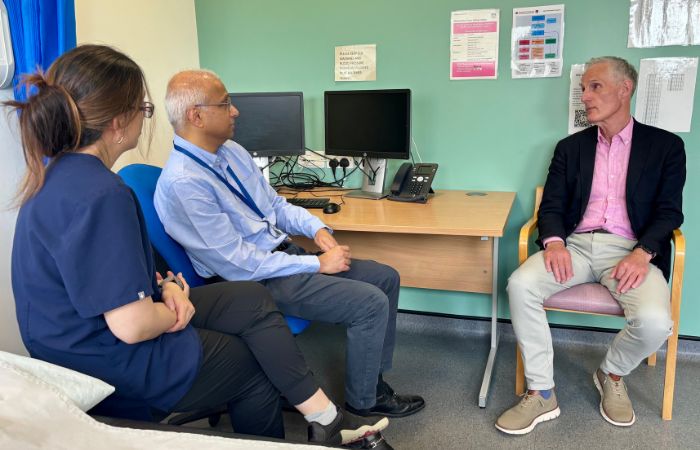 Two clinicians sitting with a patient