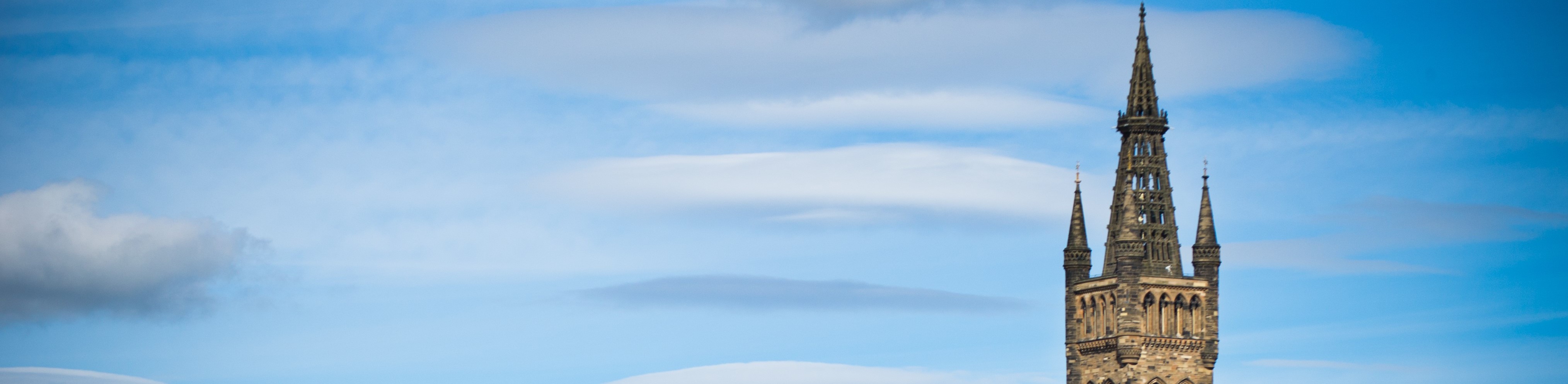 view of the top of the university tower against blue sky