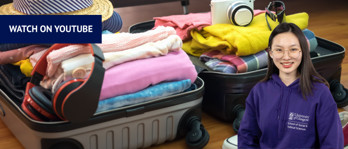 Open suitcase filled with clothes and other travel items with headshot of smiling woman