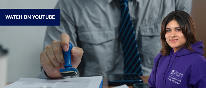 Man stamping paperwork with headshot of smiling woman in front