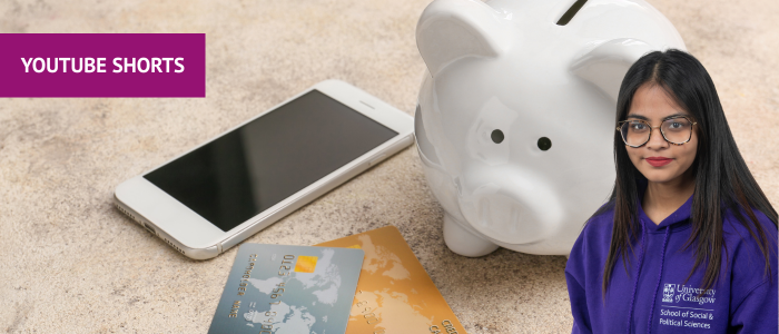 Piggy bank next to a phone and bank cards with headshot of smiling woman