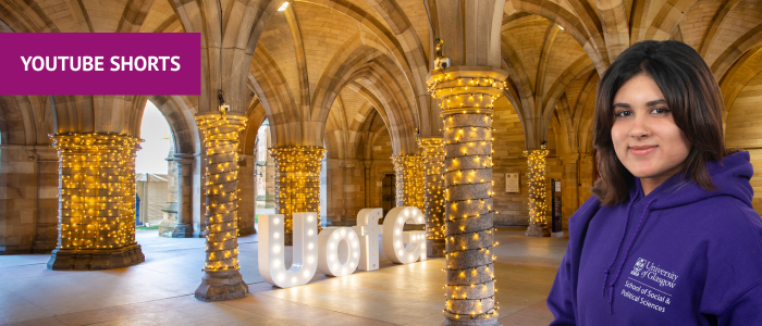 Fairy lights in the cloisters with UofG letters with headshot of smiling woman