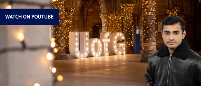 UofG letters in the cloisters with fairy lights with headshot of man