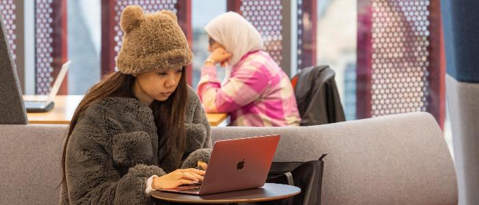 Student sitting with laptop in James McCune Smith Learning Hub