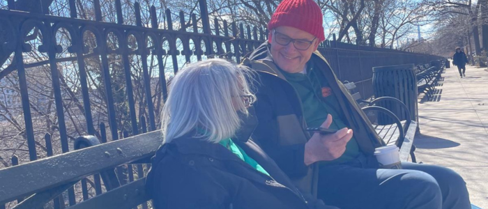 Man and woman sitting on a bench in the winter sun talking