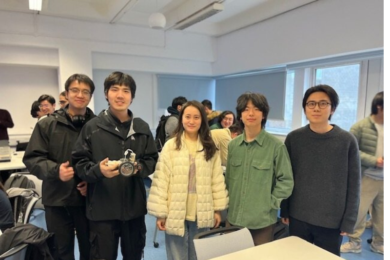 Five robotics student holding lego model