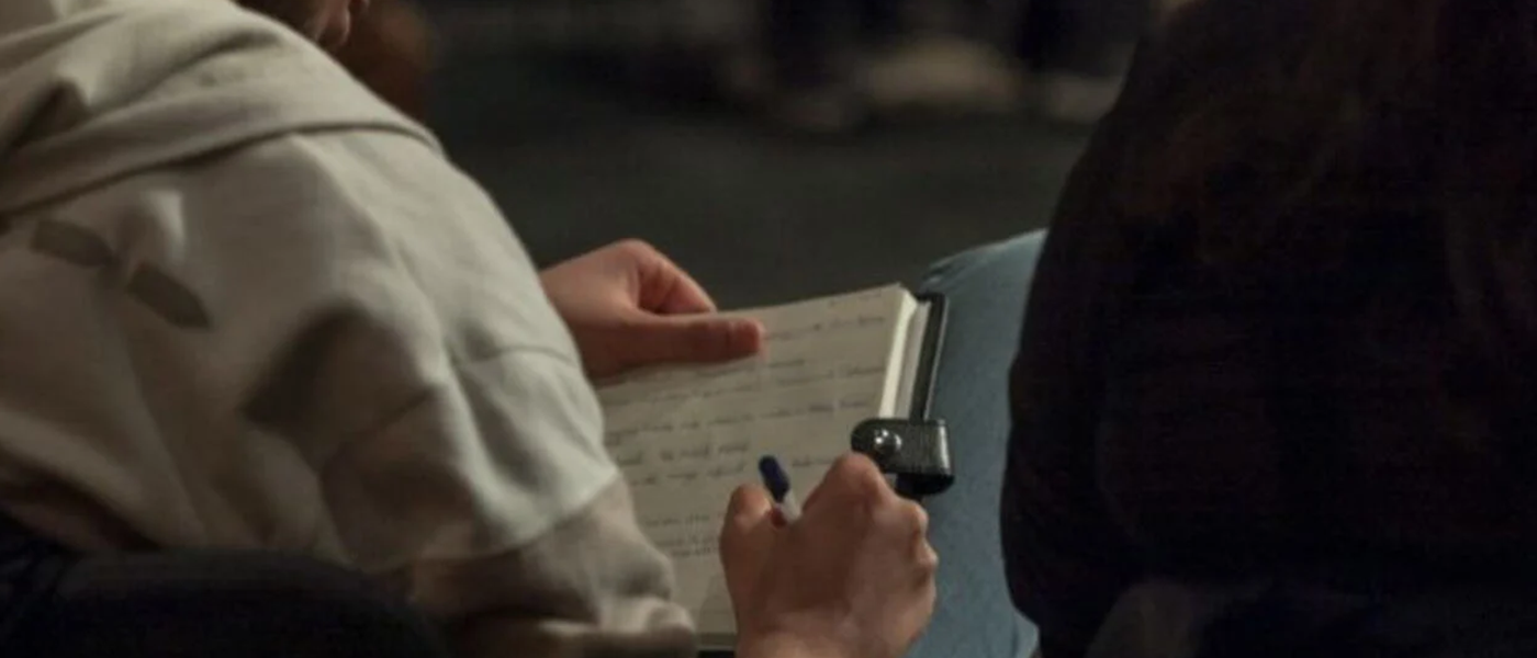 A person writing in a notebook